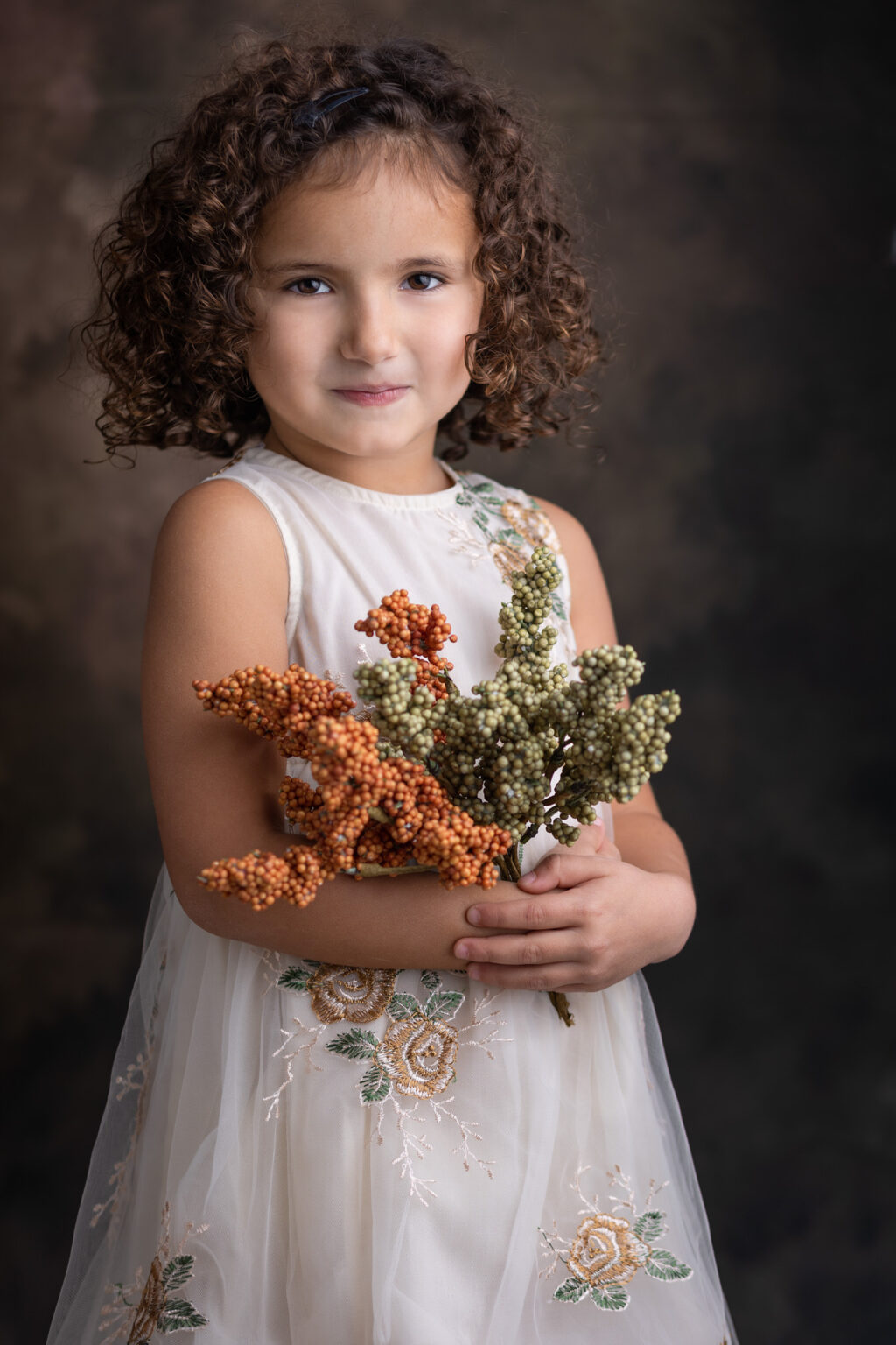 Jolie petite fille qui tient des fleurs séchées
