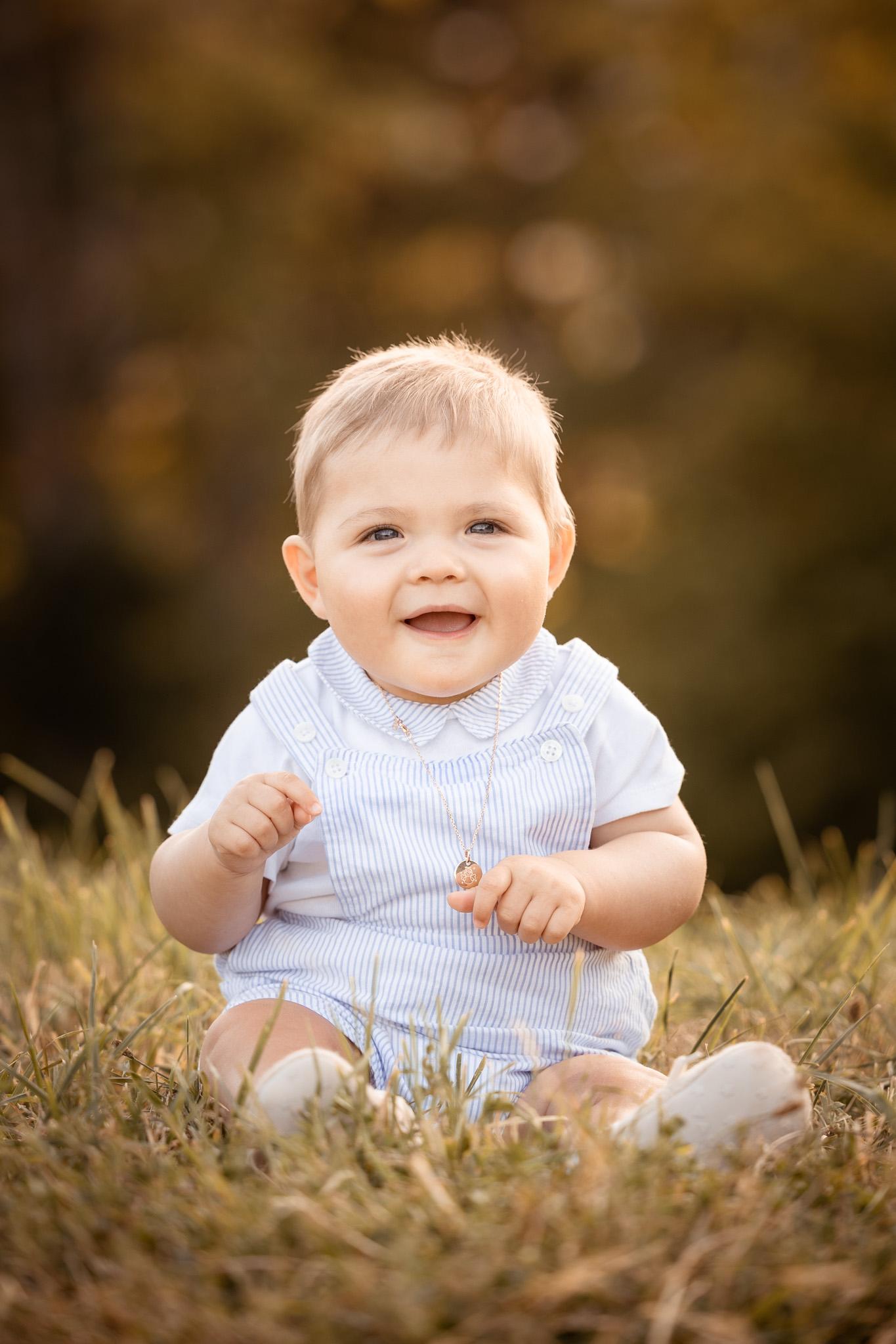 petit garcon en salopette bleu en balade 18 mois assis dans l'herbe